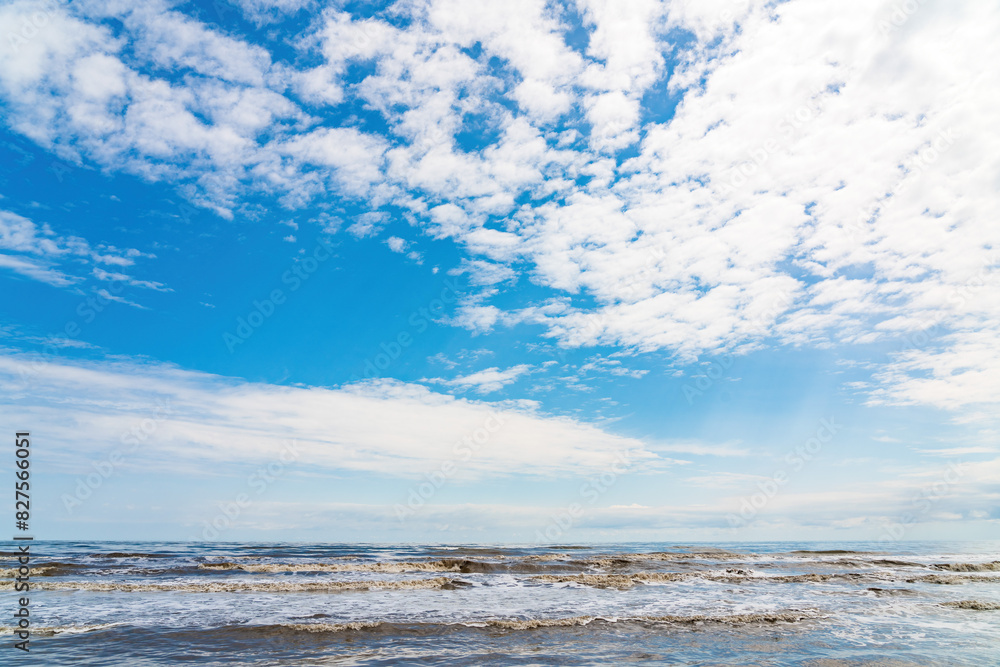 Wavy sea and blue sky with clouds