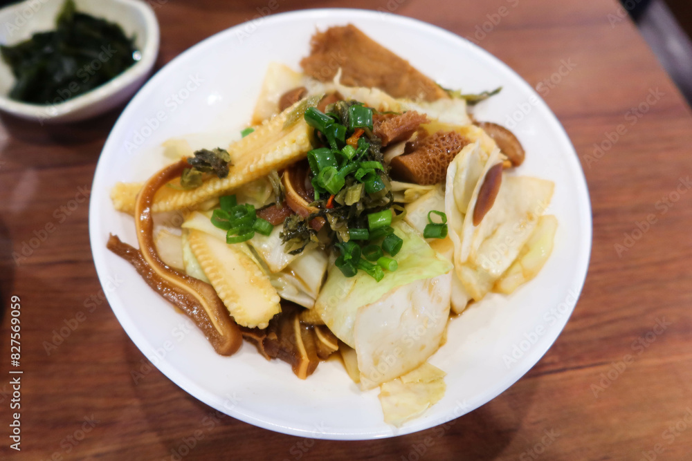 close up of Taiwanese Taiwanese braised dish with pig ear, pork, pig stomach, spring onion and cabbage on a white plate close up of Taiwanese Taiwanese braised dish with pig ear, pork, pig stomach, spring onion and cabbage on a white plate