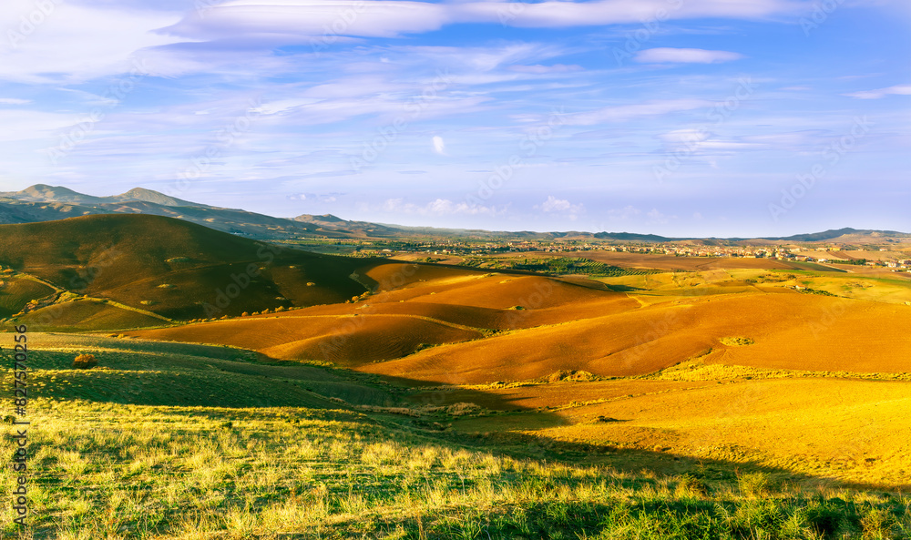 Obraz premium beautiful landscape in a yellow golden field in autumn or summer evening with nice rustic view of hills in countryside