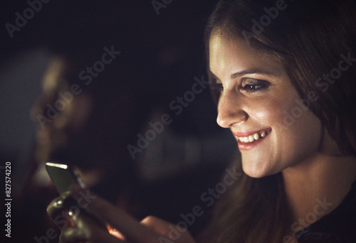 Woman, passenger and smile with smartphone at night with transport for travel, technology and communication. Conversation, reading or replying to text message with joke in Germany with taxi. photo