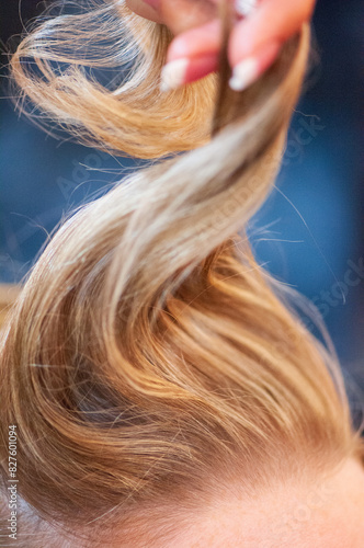 Closeup of a woman's hair being twirled and styled for a wedding