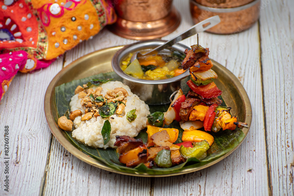 Air fried vegan barbeque seitan and vegetables skewers served on banana leaf along with Indian pongal and sambar Air fried vegan barbeque seitan and vegetables skewers served on banana leaf along with Indian pongal and sambar