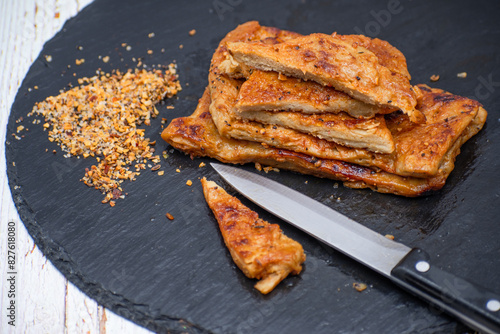 Vegan seitan schitzel slices on slate plate, cut steak style photo