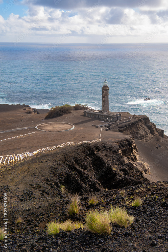 Fototapeta premium Farol da Ponta dos Capelinhos lighthouse at Faial island of the Azores, Portugal. Former beacon on the Atlantic Ocean coast. Eruption of Capelinhos volcano.