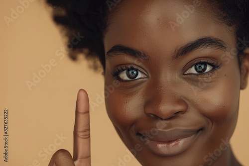 Skincare, dermatology, and cosmetics studio photograph of woman with face cream. Happy Indian woman with smile and self-care lotion on brown background. photo