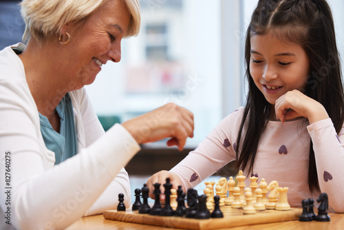 Grandmother, girl and learning chess in home to play for social or critical thinking skills, growth and development for strategy. Grandma, child and checkmate or logical game for memory and bonding.