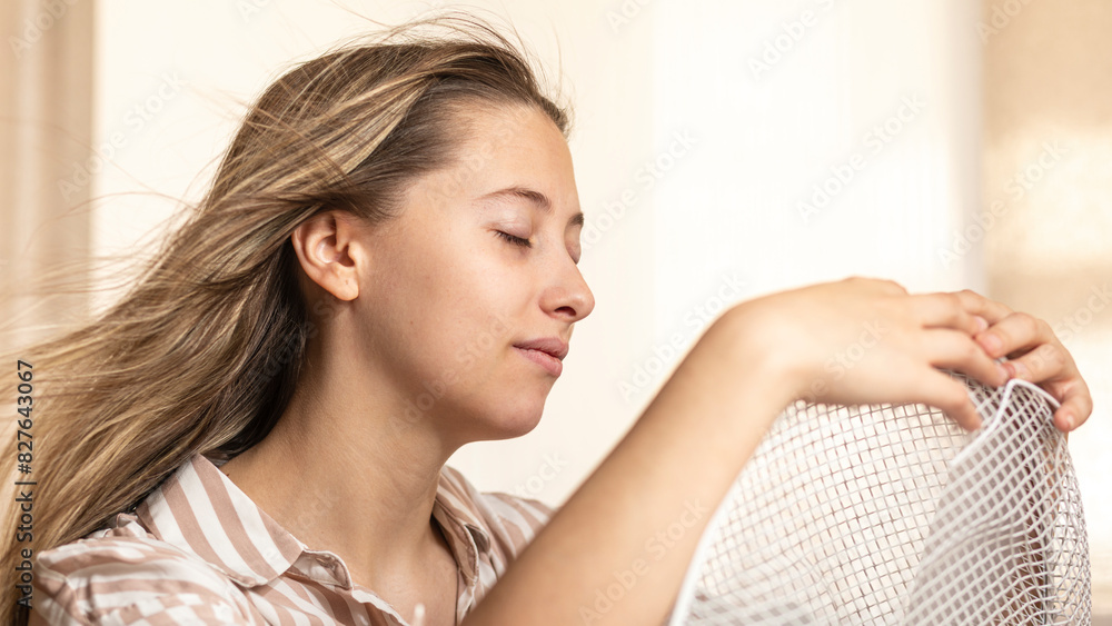 Naklejka premium woman at home cooling off in a day hot summer