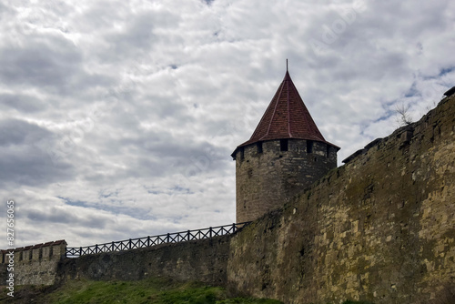 Old Stone Fortress With Conical Tower Under Cloudy Sky in Springtime. Copy space. Selective focus.