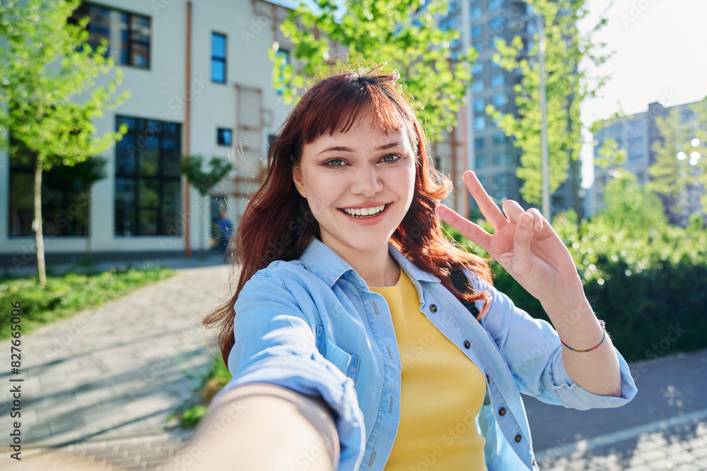 Selfie portrait of young happy red-haired female looking at camera outdoor Selfie portrait of young happy red-haired female looking at camera outdoor