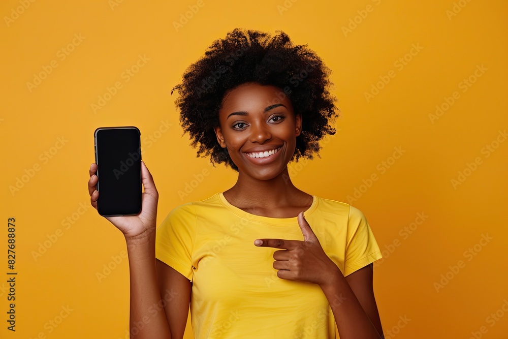 Cheerful Girl Displaying Mobile Phone on Yellow Background Cheerful Girl Displaying Mobile Phone on Yellow Background