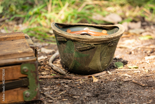 WWII german helmet on the ground. Wehrmacht m35 ( stahlhelm ) helmet in cover. Camouflage type Splinter ( splittertarnmuster ) photo