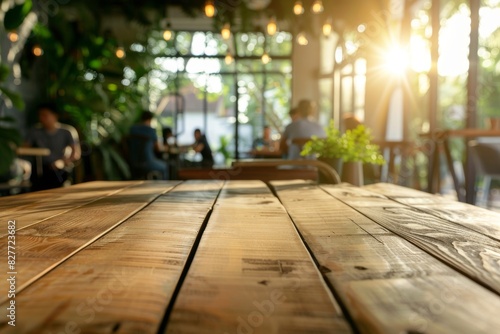 Wooden table in the foreground  with people sitting at tables and chairs in a restaurant coffee shop or eatery.