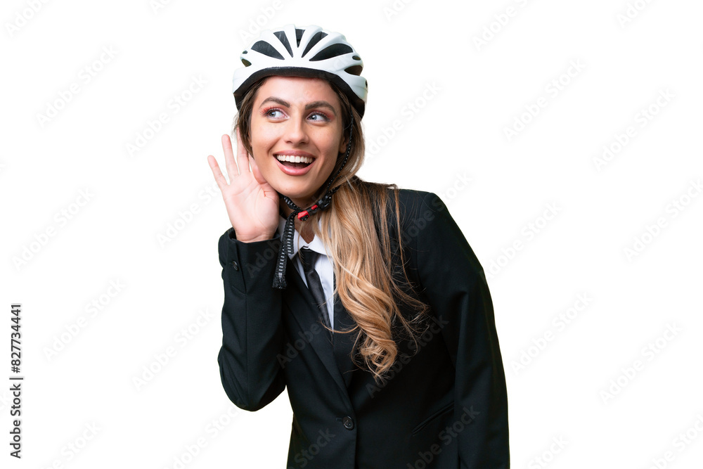 Business Uruguayan woman wearing a helmet biker over isolated background listening to something by putting hand on the ear Business Uruguayan woman wearing a helmet biker over isolated background listening to something by putting hand on the ear
