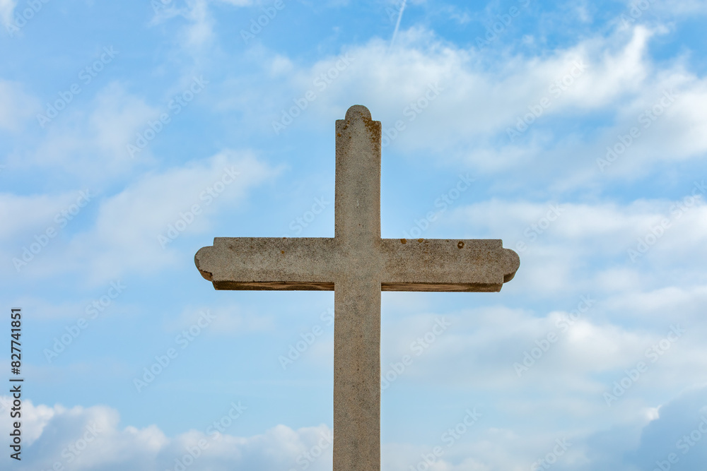 Stone Cross Against Blue Sky with Clouds - Religious Stock Photo