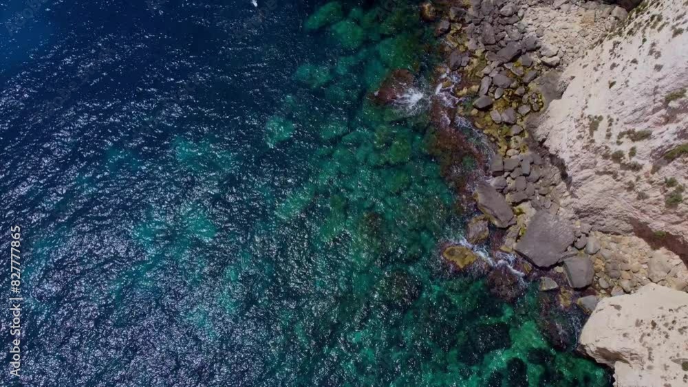 Aerial sea view. emerald and blue water with purple algae on the rocky coasr. Sea water backgound. Malta, blue Grotto coast. High quality 4k footage Aerial sea view. emerald and blue water with purple algae on the rocky coasr. Sea water backgound. Malta, blue Grotto coast. High quality 4k footage
