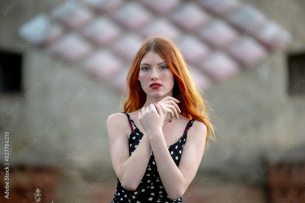 Naklejka premium Portrait of a redhead girl with long hair at the city.