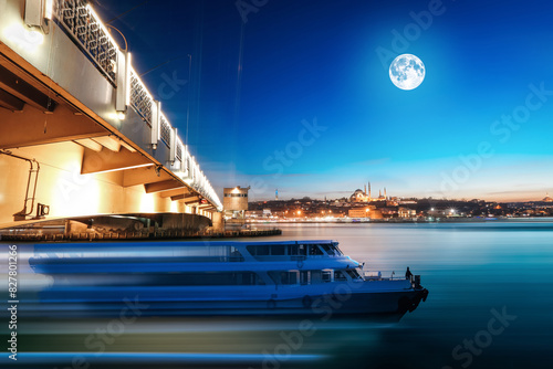 Beautiful night landscape of Galata bridge, full moon, lights, passenger boat and bosphorus of golden horn, Istanbul in Turkey. photo