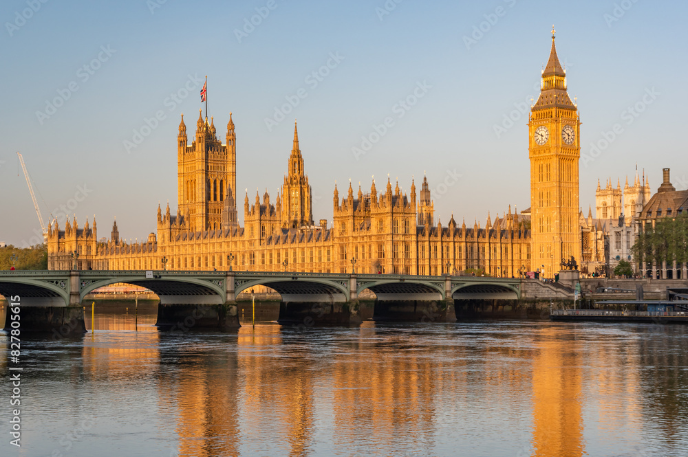 Early sunny morning with Palace of Westminster and Big Ben clock tower seen across River Thames, London, United Kingdom