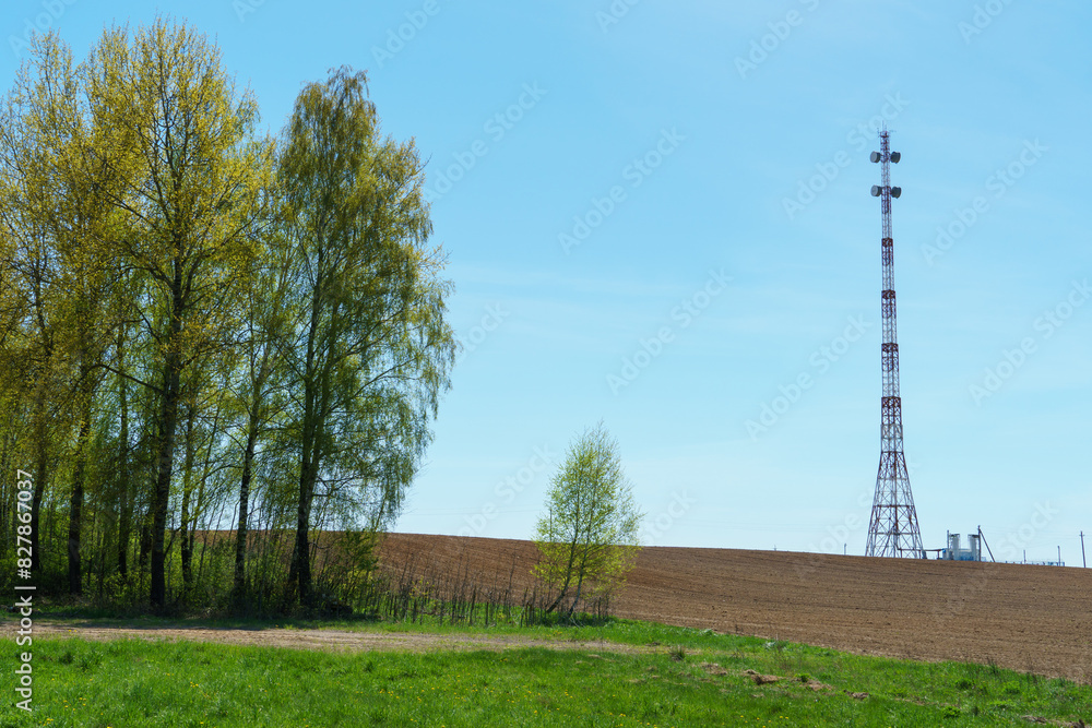 New GSM antennas on a high tower against a blue sky background. 5G signal transmissions are dangerous to health. Radiation pollution of the environment through cell towers. Harm to health