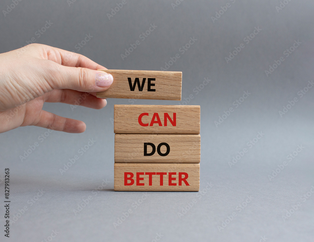 We Can Do Better symbol. Concept words We Can Do Better on wooden blocks. Beautiful grey background. Businessman hand. Business and We Can Do Better concept. Copy space. We Can Do Better symbol. Concept words We Can Do Better on wooden blocks. Beautiful grey background. Businessman hand. Business and We Can Do Better concept. Copy space.