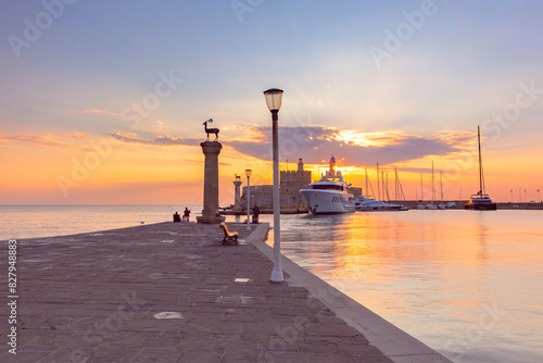 Mandraki Harbor with iconic deer statue on column and St Nicholas Fortress in Rhodes, Greece