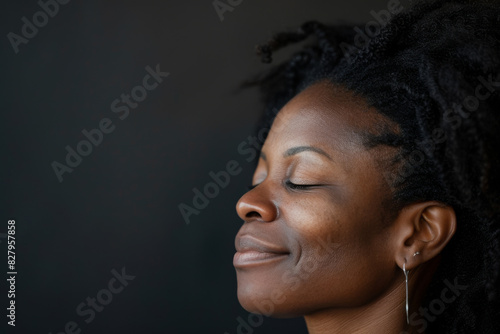 A close up of a black woman's face with her eyes closed looking to a side © MagnusCort