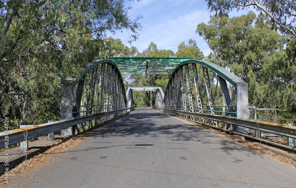 Border Bridge with arches crossing the Macintyre River surrounded by trees under a blue sky in Goondiwindi, Queensland, Australia