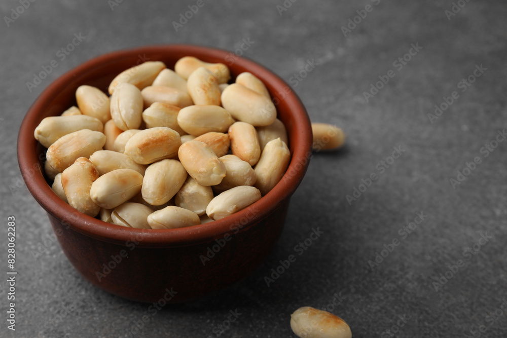 Roasted peanuts in bowl on brown table, closeup. Space for text Roasted peanuts in bowl on brown table, closeup. Space for text