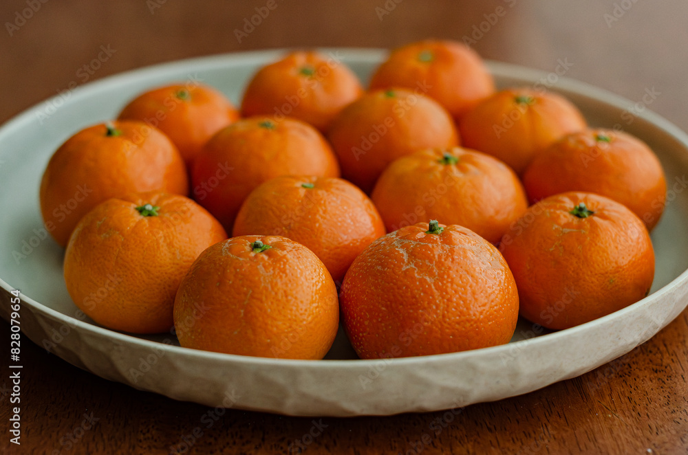 Clementine oranges in plate naturally lit arranged wooden background Clementine oranges in plate naturally lit arranged wooden background