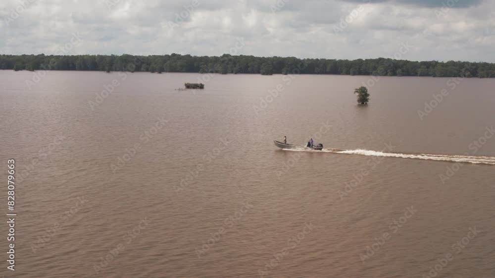Aerial Panning Shot Of People Driving Motorboat On Rippled River During Sunny Day - Bayou Vista, Texas Aerial Panning Shot Of People Driving Motorboat On Rippled River During Sunny Day - Bayou Vista, Texas