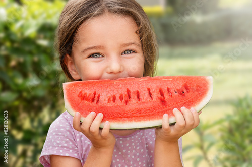 Happy girl child holding watermelon in backyard
