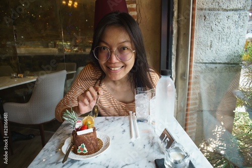 asian women eating chocolate cake in cafe