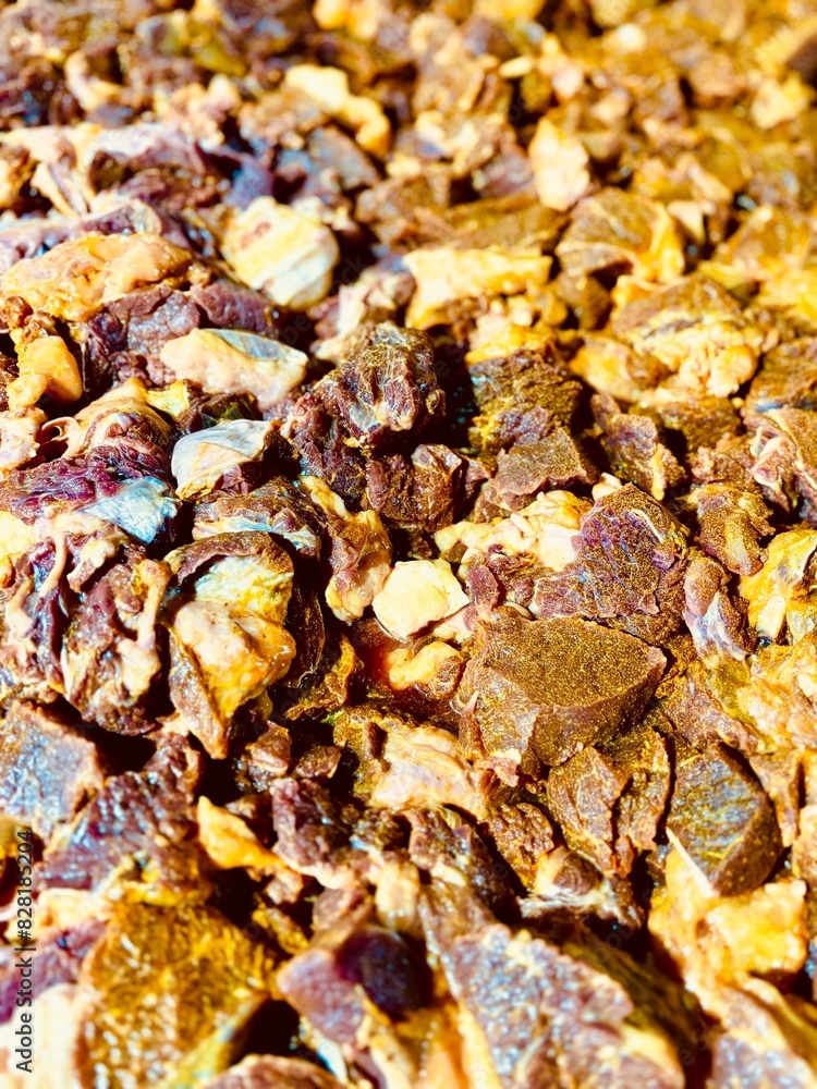 Close-up of raw beef pieces seasoned with vibrant turmeric powder, ready for cooking. The rich yellow spice contrasts beautifully with the fresh meat, highlighting a traditional culinary preparation p Close-up of raw beef pieces seasoned with vibrant turmeric powder, ready for cooking. The rich yellow spice contrasts beautifully with the fresh meat, highlighting a traditional culinary preparation p