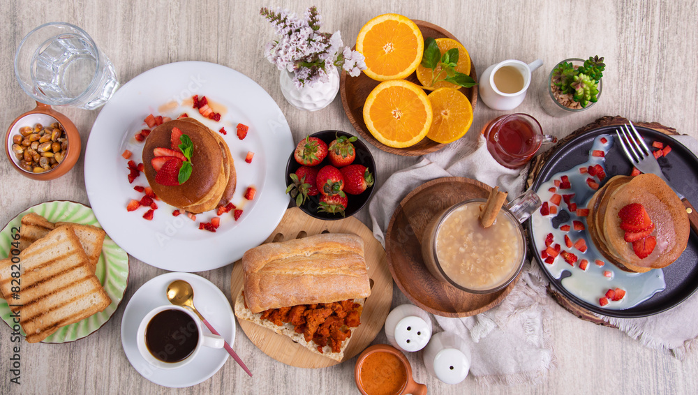 Breakfast table full of food brunch pancakes, bread and fruit Breakfast table full of food brunch pancakes, bread and fruit