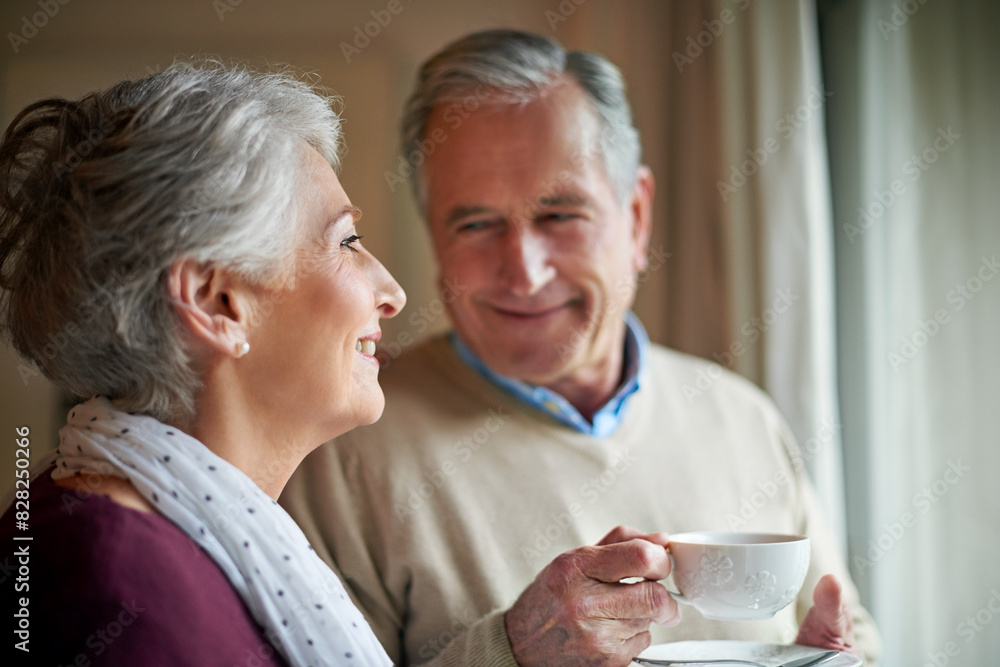 Senior couple, tea and window in home for relax, love and drink for married man and woman. Living room, house and calm for retired people together, coffee or beverage for romance and peace in Germany Senior couple, tea and window in home for relax, love and drink for married man and woman. Living room, house and calm for retired people together, coffee or beverage for romance and peace in Germany