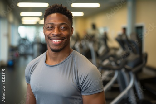 Muscular African American man in gym  fitness trainer smiling and looking at the camera on the background of the fitness center. healthy lifestyle and sports.