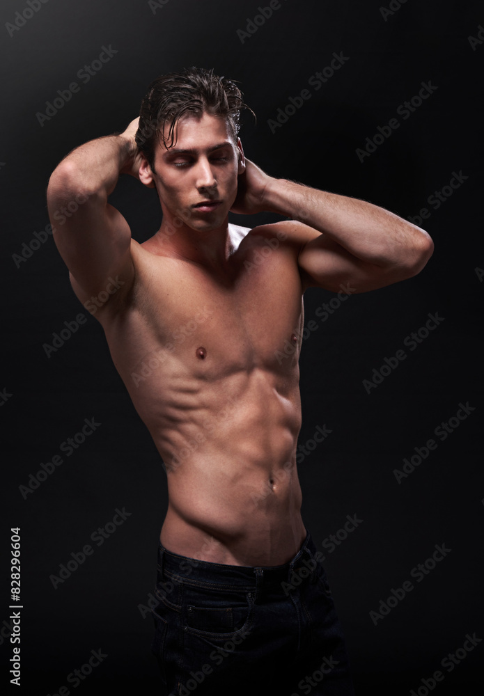 Fototapeta premium Sexy, skin and man in studio for workout with fitness goals, sport training and progress results for muscle growth. Personal trainer, guy and torso abs for strong body and health by black background