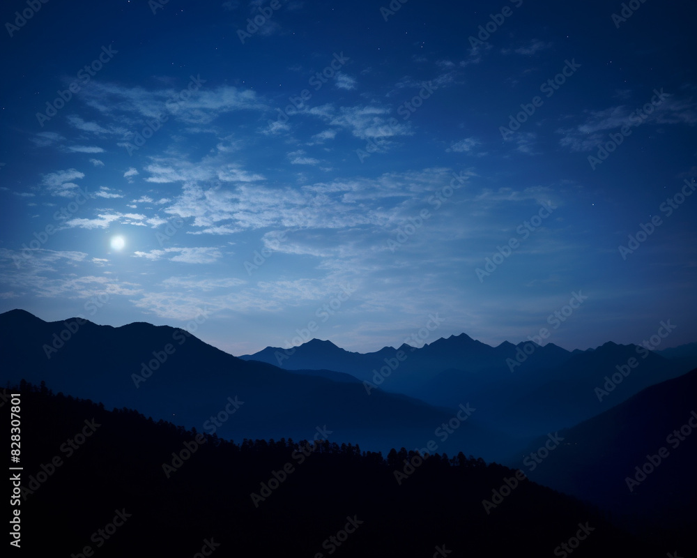 Obraz premium Serene night mountain landscape under a starry sky with moonlight casting shadows over the ridges and valleys, creating a tranquil atmosphere.