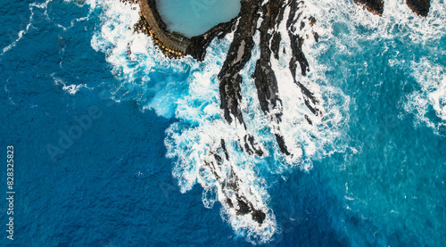 Aerial view of rough ocean with waves, volcanic beach and swiming pool in Seixal, Madeira, Portugal photo