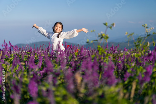 Asian child or kid girl on beauty of many fresh flowers to happy smile on beautiful pink violet in nature flower field garden on valentine holiday travel by mountain sky view at Yingyong flower garden