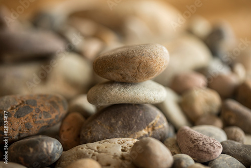 Pile of pebbles on the beach at sunset symbolizing a zen philosophy of peace and tranquility