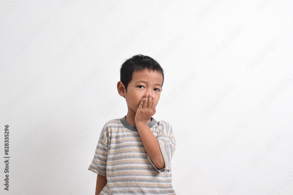 Image of Asian child posing covering his mouth with both hands on a white background. portrait of an Asian boy Image of Asian child posing covering his mouth with both hands on a white background. portrait of an Asian boy