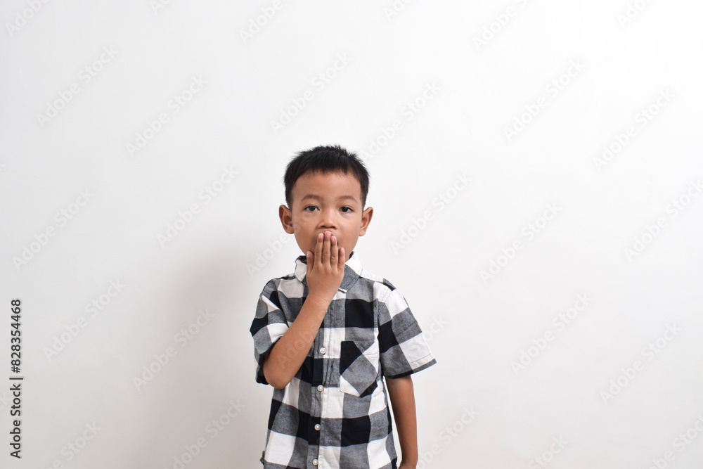 Image of Asian child posing covering his mouth with both hands on a white background. portrait of an Asian boy Image of Asian child posing covering his mouth with both hands on a white background. portrait of an Asian boy
