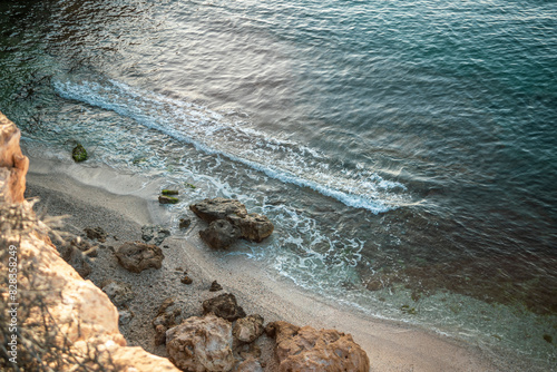 View from above of Cala Blanca of the Puntas de Calnegre regional park in the Region of Murcia, Spain with gentle waves and rocks on the shore photo