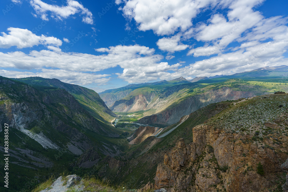 Naklejka premium panorama of the landscape, Altai, pass, mountain slopes, valley, bends of the road, white clouds in the blue sky
