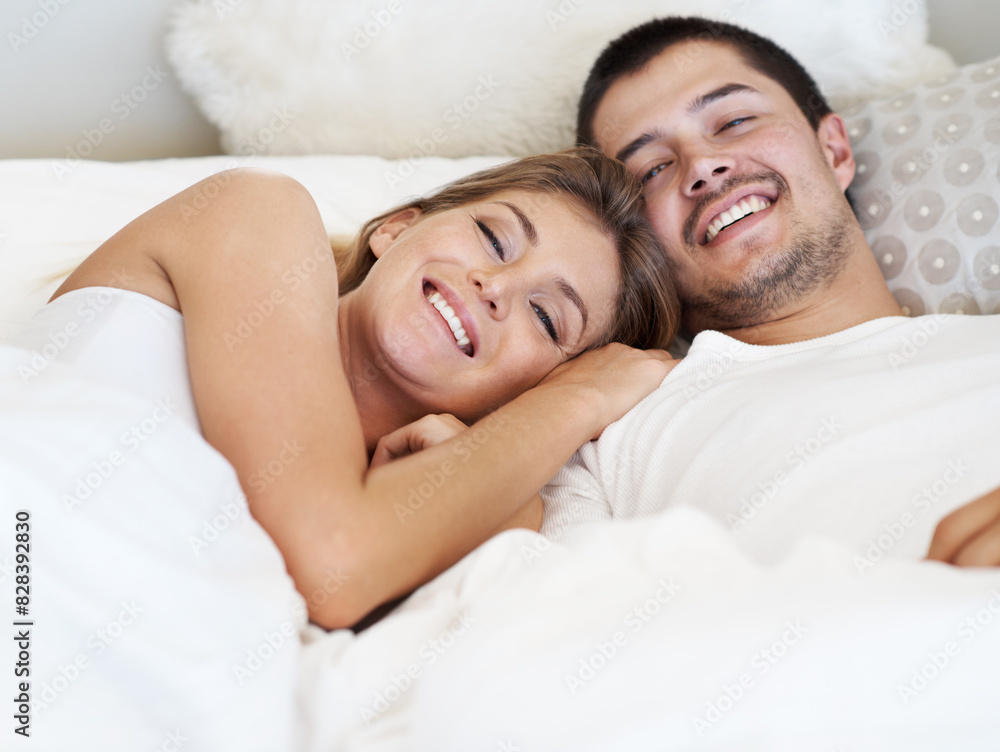 Man, woman and portrait in bed, house and connection with smile, rest and wake up in morning with hug. Couple, embrace and happy with blanket, comfort and relax with love, care and bedroom in home