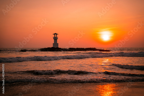 A lighthouse in the ocean during a beautiful sunset