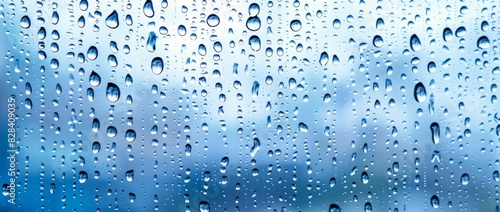 Raindrops on window glass with blue sky backdrop