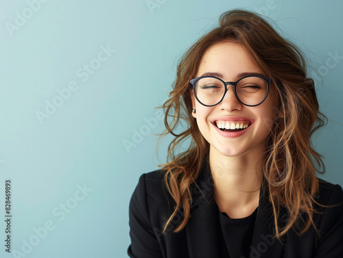 Junge Geschäftsfrau mit Brille lächelt an ihren Arbeitsplatz in die Kamera. Busineesfoto einer erfolgreichen und symphatischen Frau photo