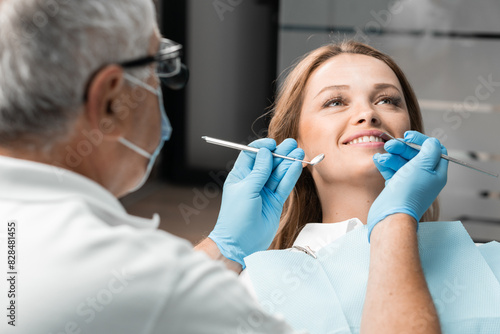 A patient is comfortably seated in the dental chair  whose bright smile adorns the office. The dentist stands nearby  ready to provide qualified assistance and make every visit pleasant and painless.